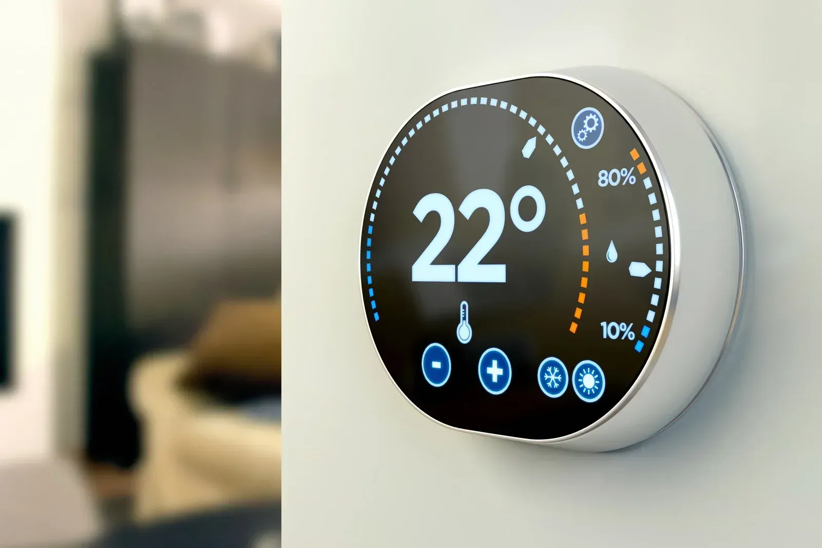 A thermostat on a wall with the temperature at 22 degrees