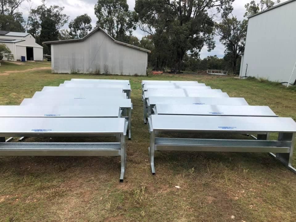 A Row of Metal Tables Are Sitting in A Grassy Field — Ballimore Welding in Ballimore, NSW
