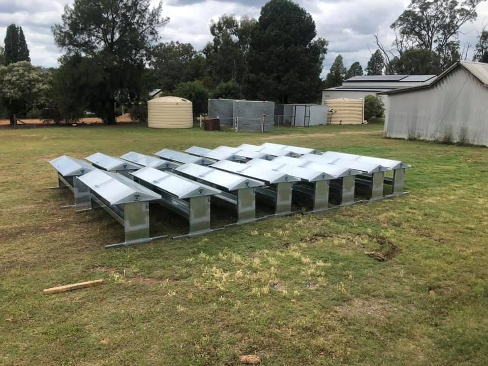 A Row of Metal Benches Are Sitting in A Grassy Field — Ballimore Welding in Ballimore, NSW