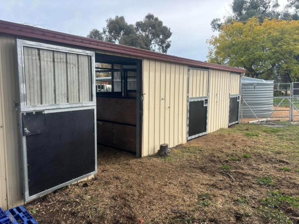 A horse Stable with The Doors Open in A Field — Ballimore Welding in Tamworth, NSW
