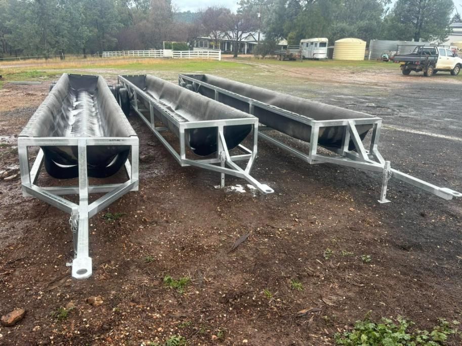 Three Metal Troughs Are Sitting on Top of A Dirt Field — Ballimore Welding in Ballimore, NSW