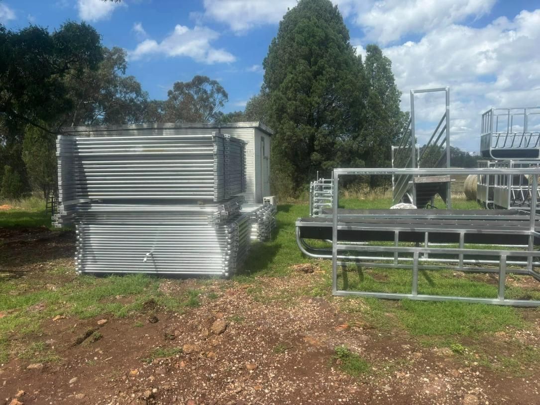 A Stack of Metal Fences Are Sitting in A Grassy Field — Ballimore Welding in Orange, NSW