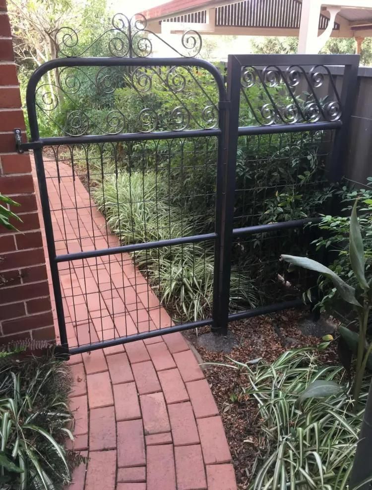 A Black Gate Is Sitting on A Brick Walkway Next to A Brick Wall — Ballimore Welding in Ballimore, NSW