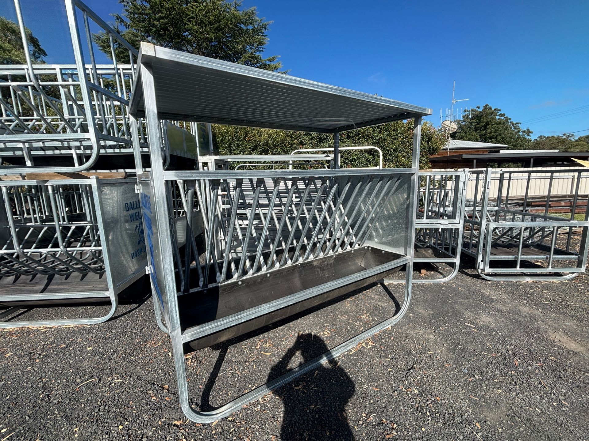 A Metal Fence with A Roof Is Sitting on Top of A Dirt Field — Ballimore Welding in Ballimore, NSW