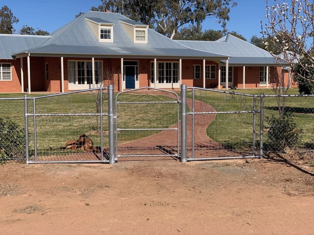 A Large Brick House With a Metal Fence in Front of It — Ballimore Welding in Ballimore, NSW