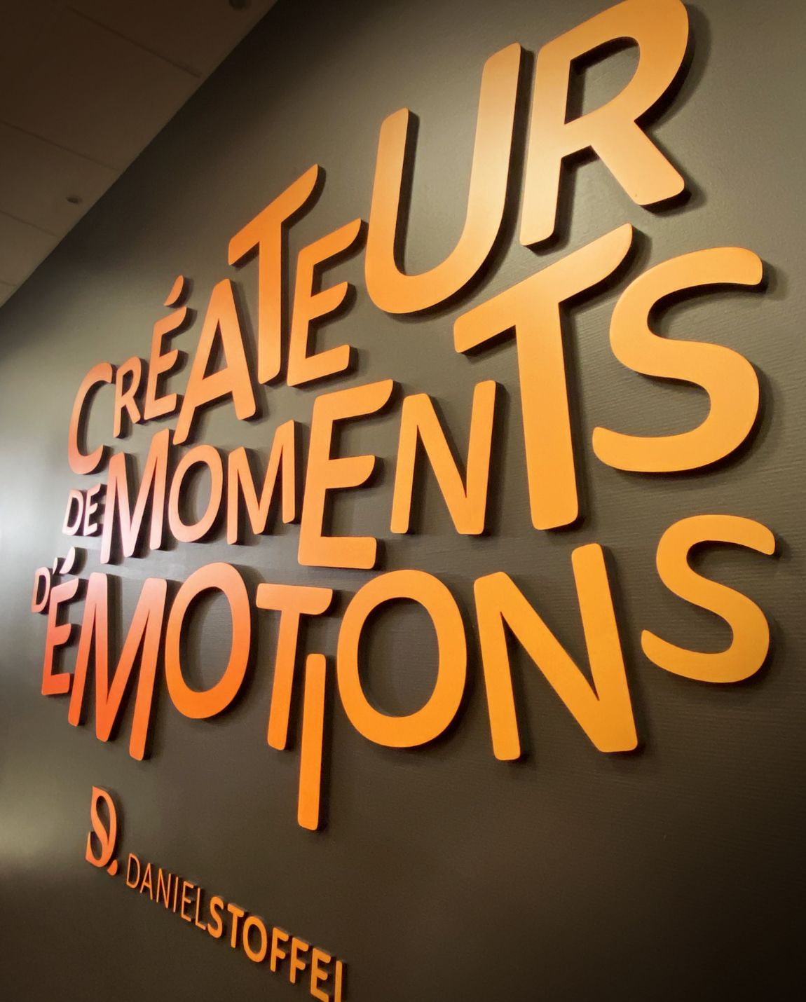 Lettres orange sur mur gris foncé : 