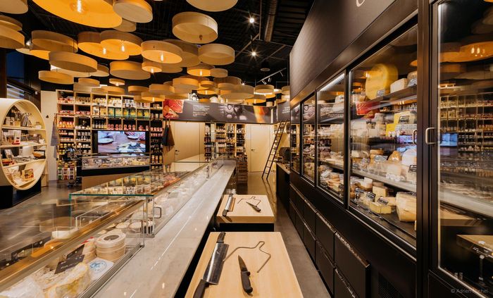 Intérieur d'une fromagerie avec des vitrines remplies de produits.