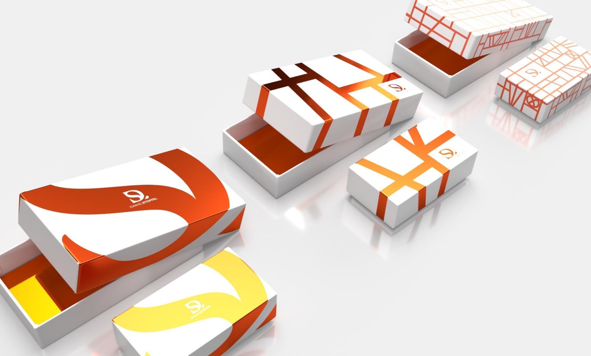 Boîtes avec motifs orange et jaune et rubans sur fond blanc.