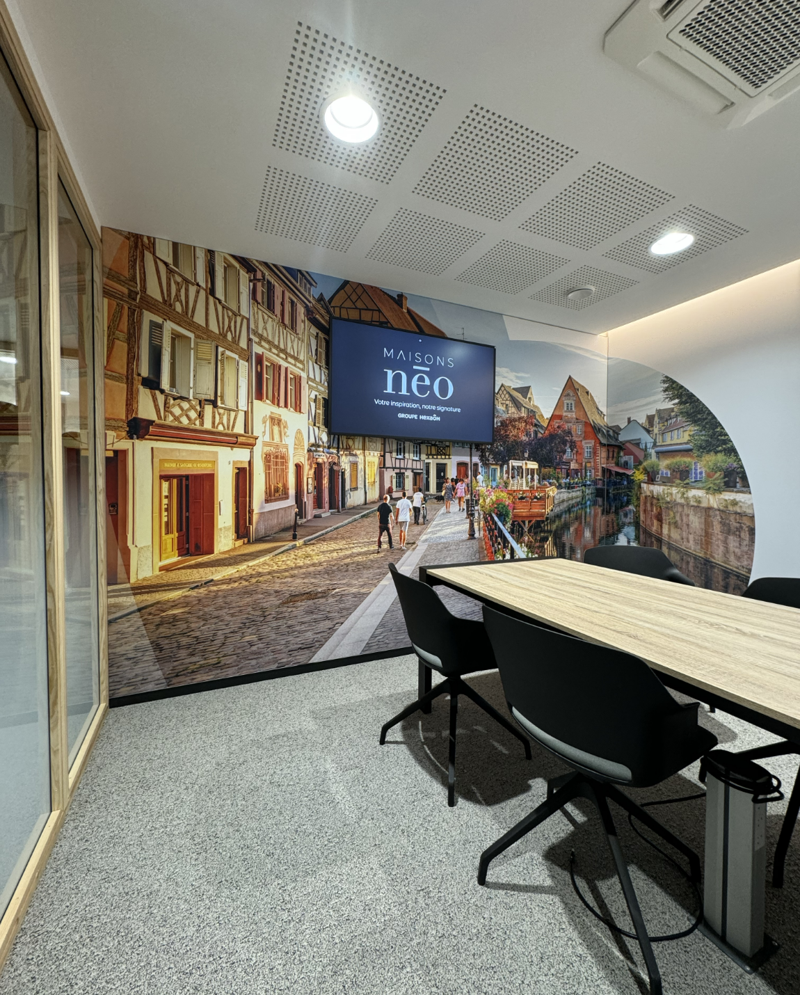 Salle de conférence avec fresque de rue, table, chaises, écran de télévision et plafond texturé.