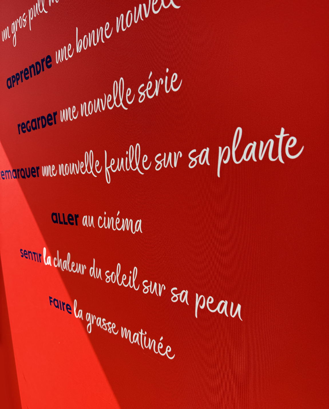 Fond rouge avec texte cursif blanc en français. Le texte décrit des actions comme « bonne nouvelle » et « nouvelle page ».