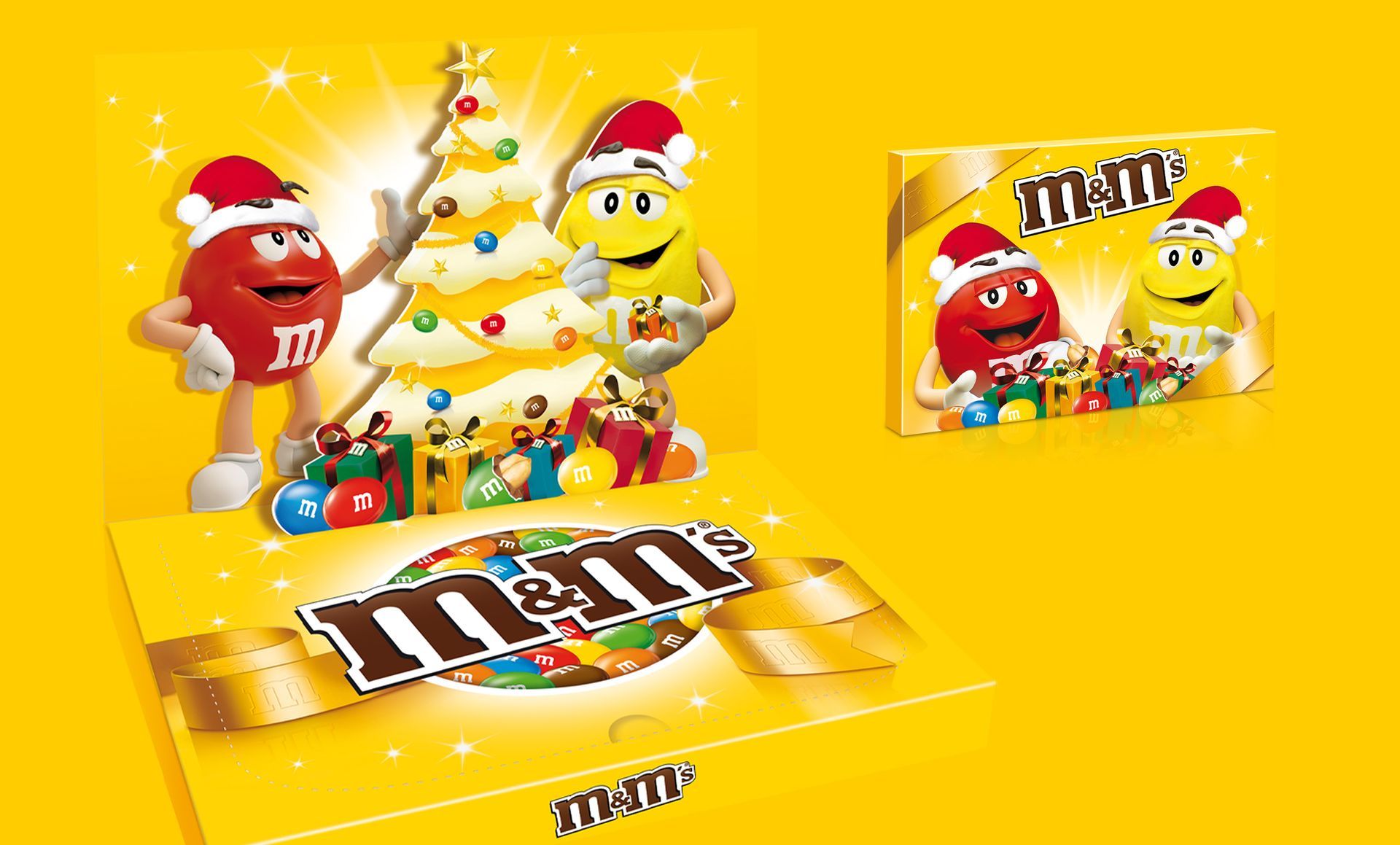 Personnages de M&M's portant des bonnets de Père Noël, à côté d'un sapin de Noël. Cadeaux de bonbons, fond doré.