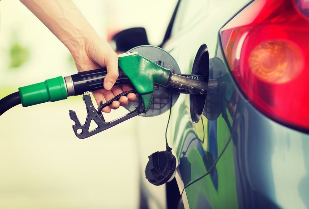 A Person Is Pumping Gas Into A Car At A Gas Station — MB Automotive In Garbutt, QLD