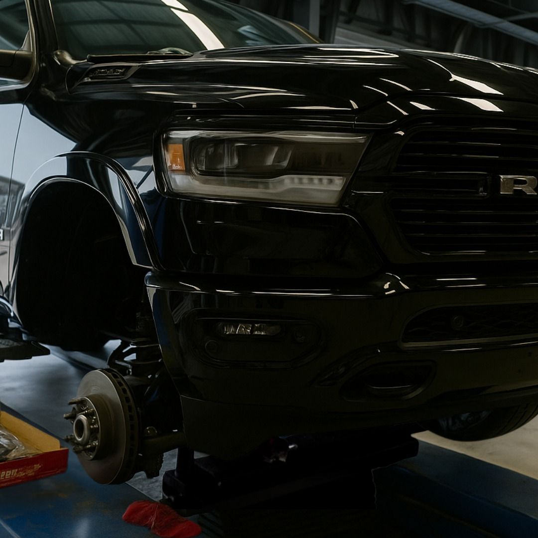 Black Truck Elevated With Front Wheel Removed In Garage