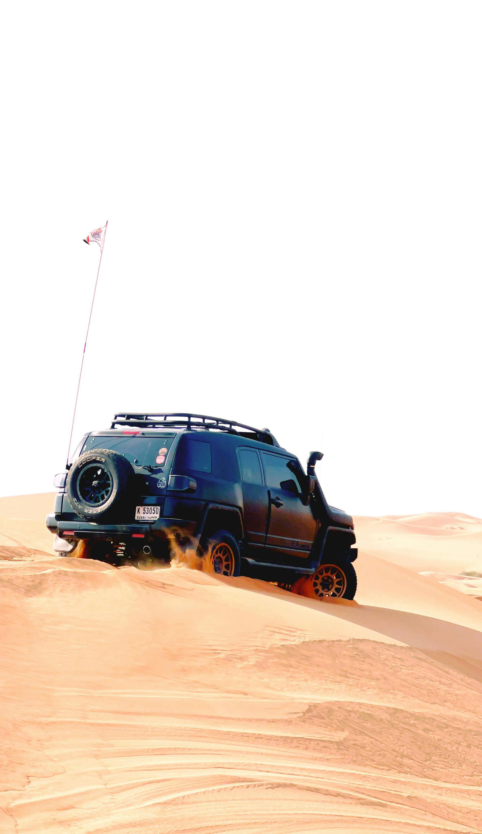 A black suv is driving through the sand in the desert. — MB Automotive In Garbutt, QLD