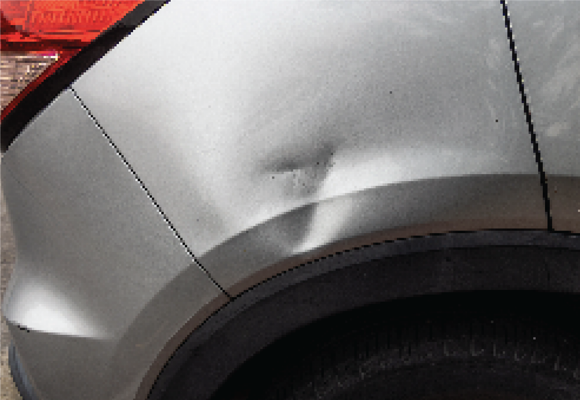 A person is holding a tool in their hands on a car hood.