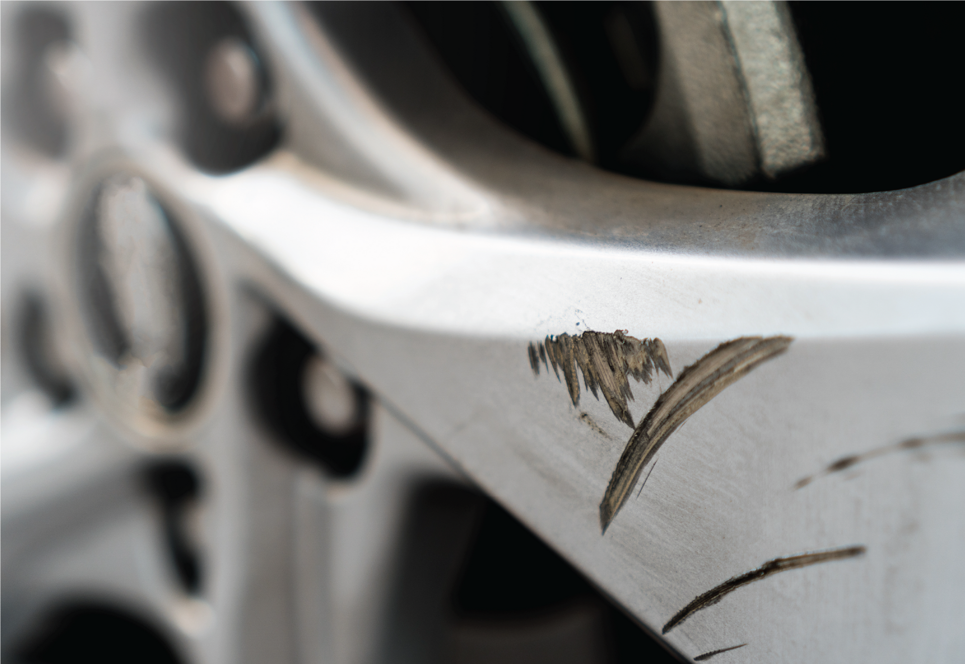 A man is polishing the hood of a blue car.