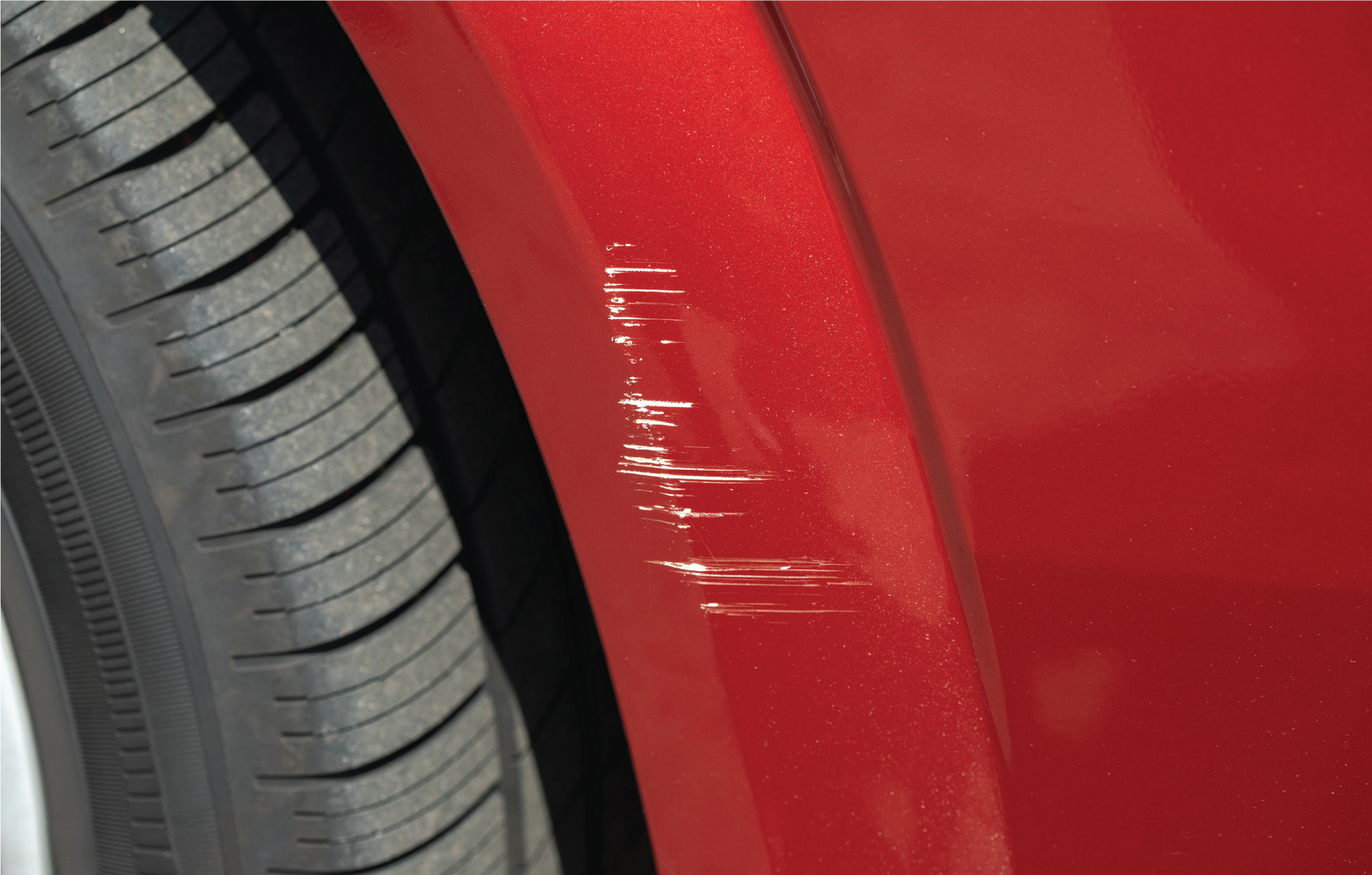 A close up of a car with a scratch on the front bumper