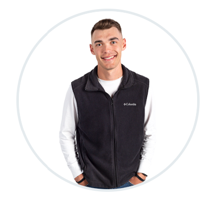 a man is wearing a black columbia vest and smiling .