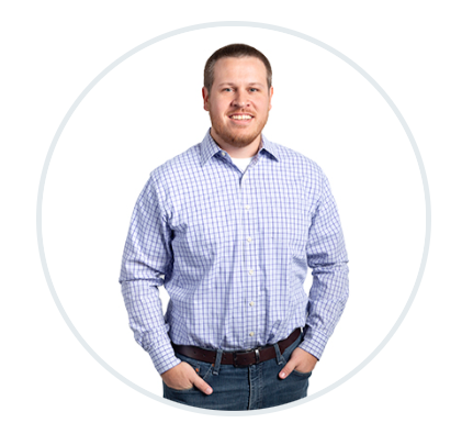 a man in a blue shirt is standing in a circle with his hands in his pockets .