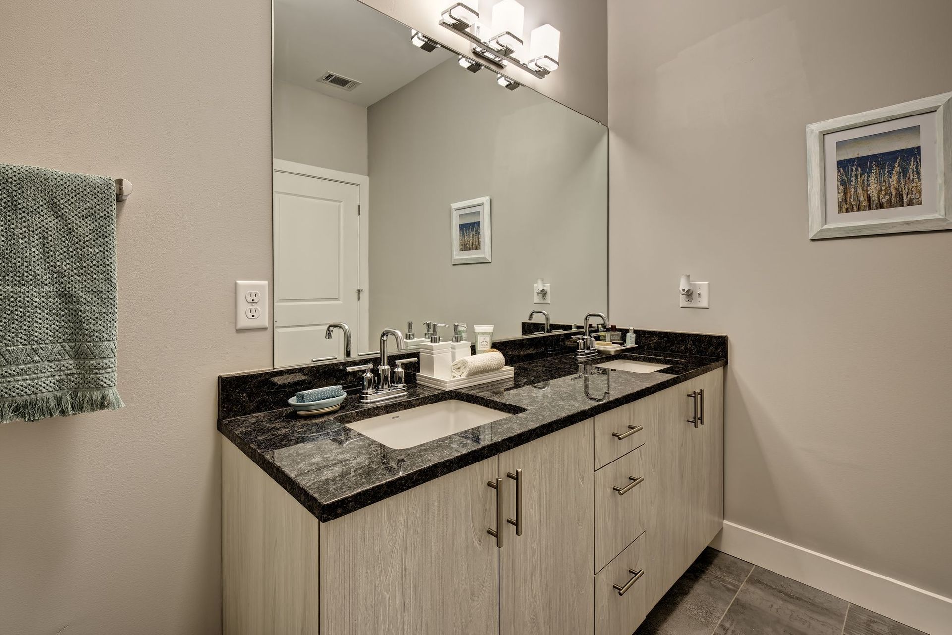 A bathroom with two sinks and a large mirror.