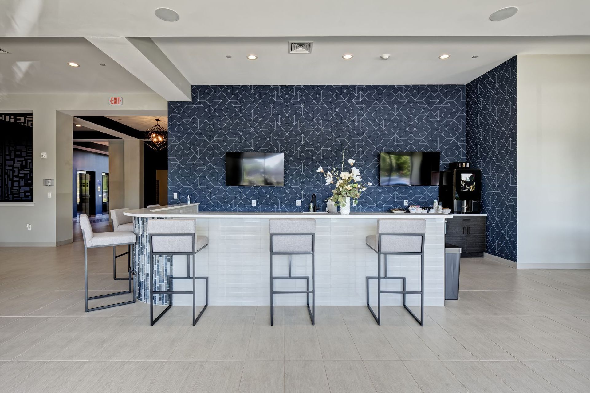 A large room with a bar and stools in it