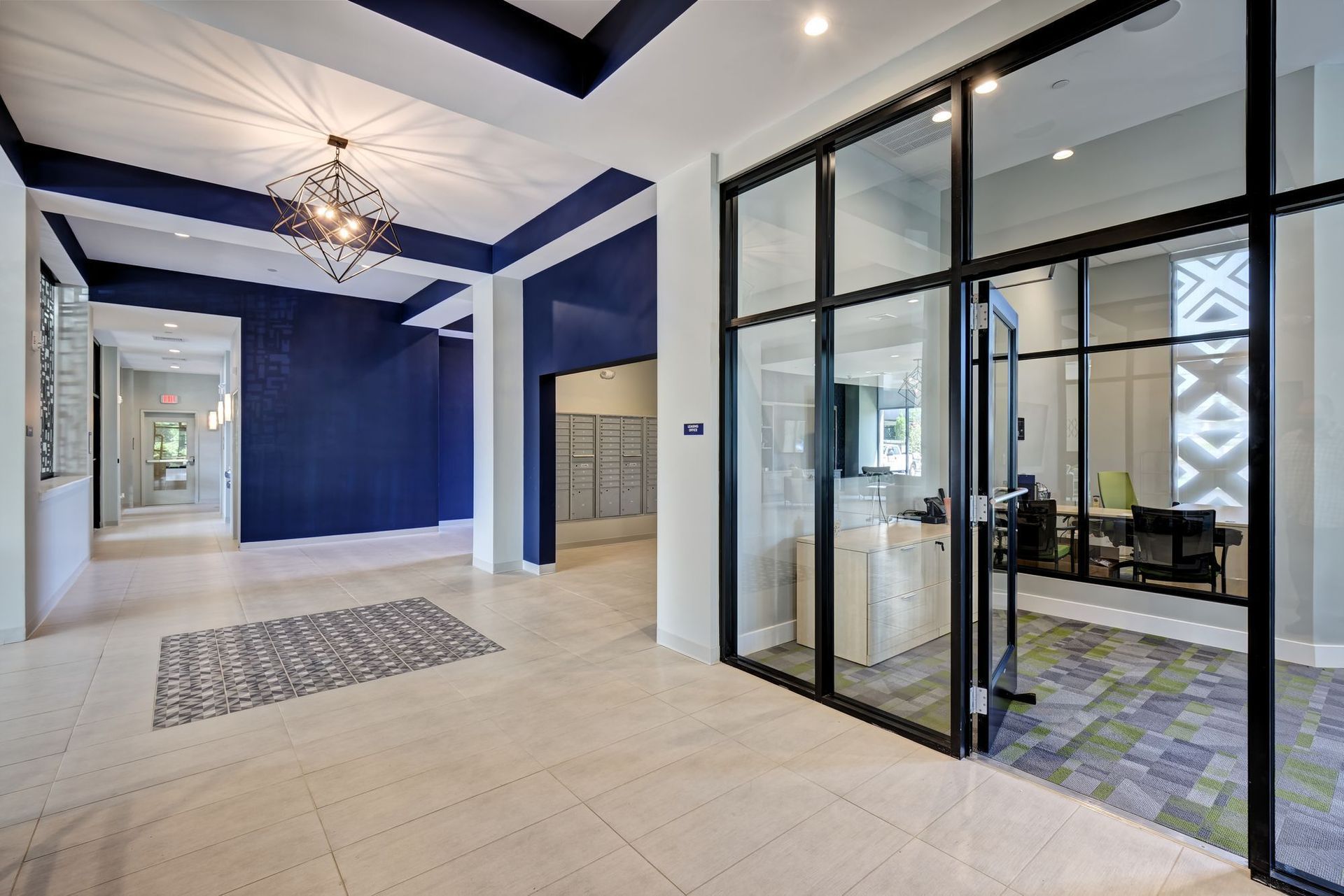 A large lobby with a lot of glass doors and a chandelier.
