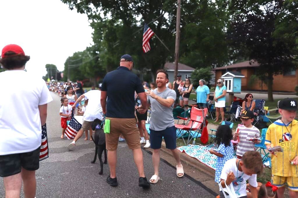A group of people are walking down a street in a parade.