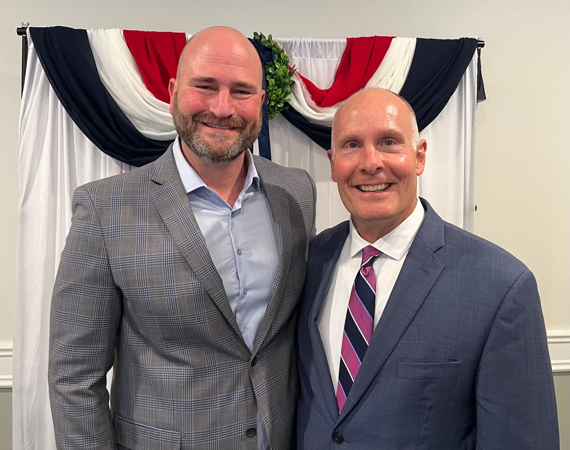 Two men in suits and ties are posing for a picture.