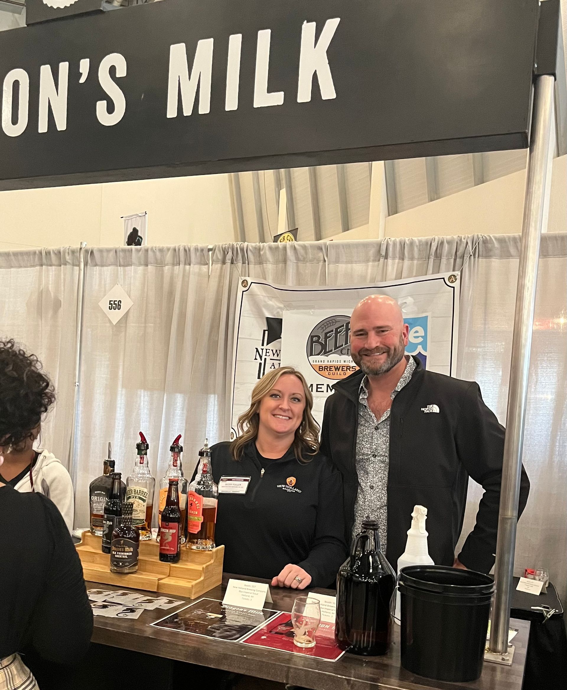 A man and a woman are standing in front of a sign that says ' on 's milk '