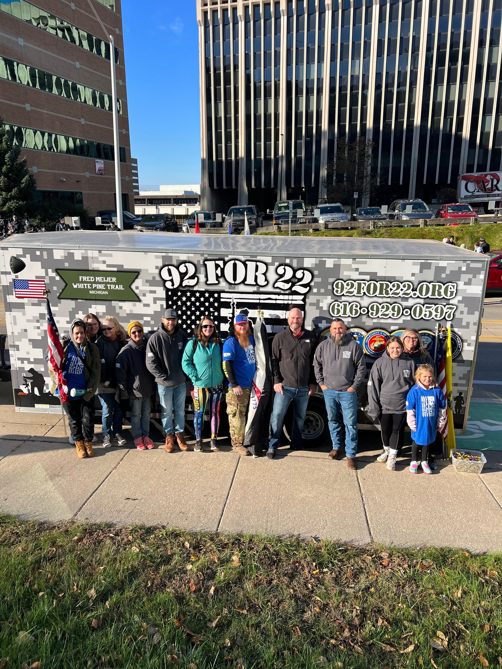 A group of people are posing for a picture in front of a truck.