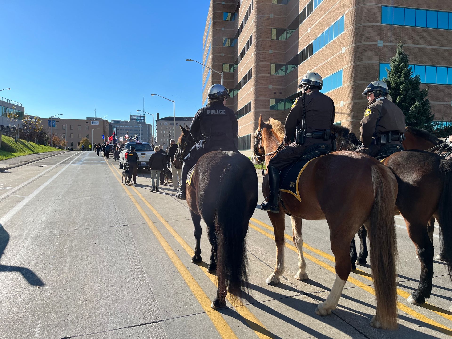 A group of police officers are riding horses down a street.