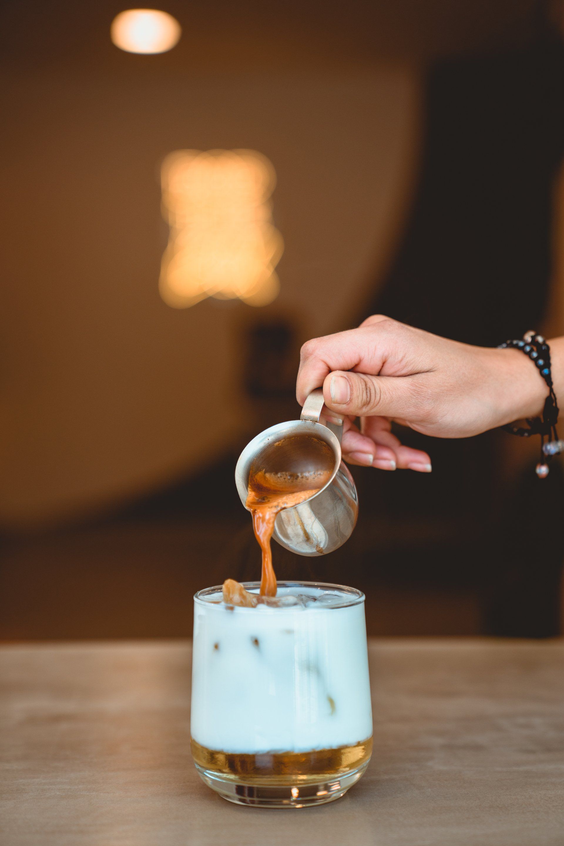 Pouring Coffee Into a Glass of Milk