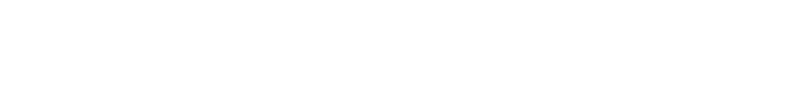 A group of people wearing blue shirts standing in a circle and holding hands on a grassy field.