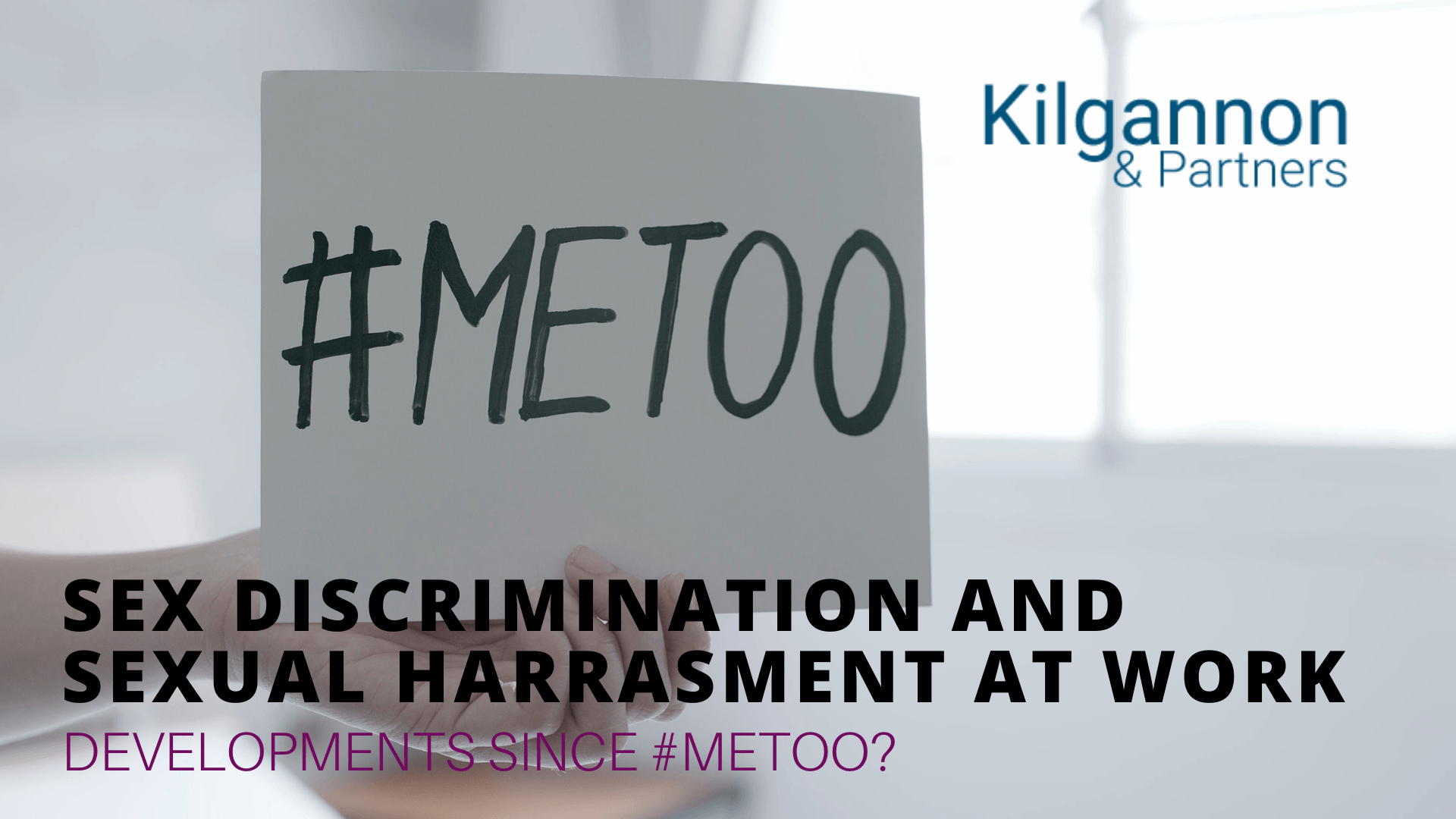 A hand holds a sign reading 