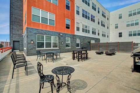 A large building with tables and chairs in front of it