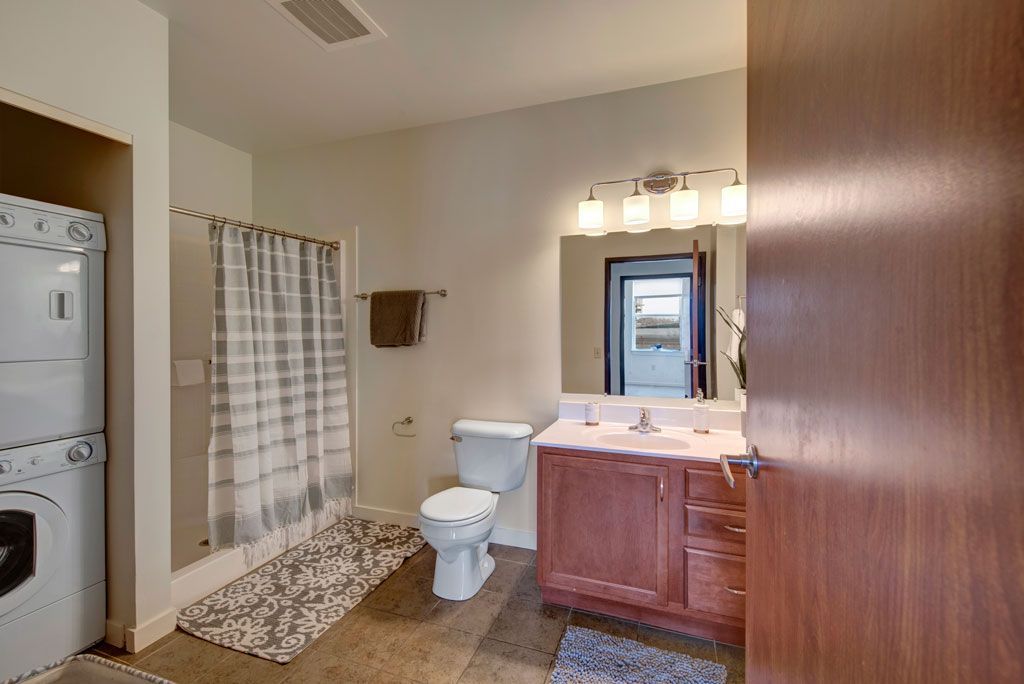 A bathroom with a washer and dryer stacked on top of each other.