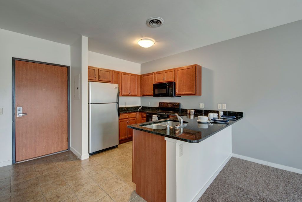 A kitchen with a refrigerator , stove , sink and microwave.