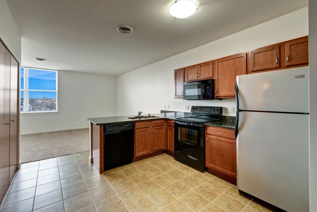 A kitchen with a refrigerator , stove , microwave and dishwasher.