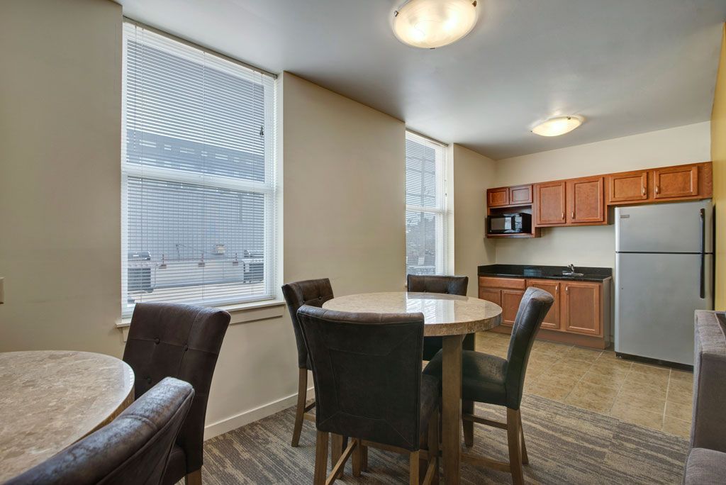 A kitchen with a table and chairs and a refrigerator.