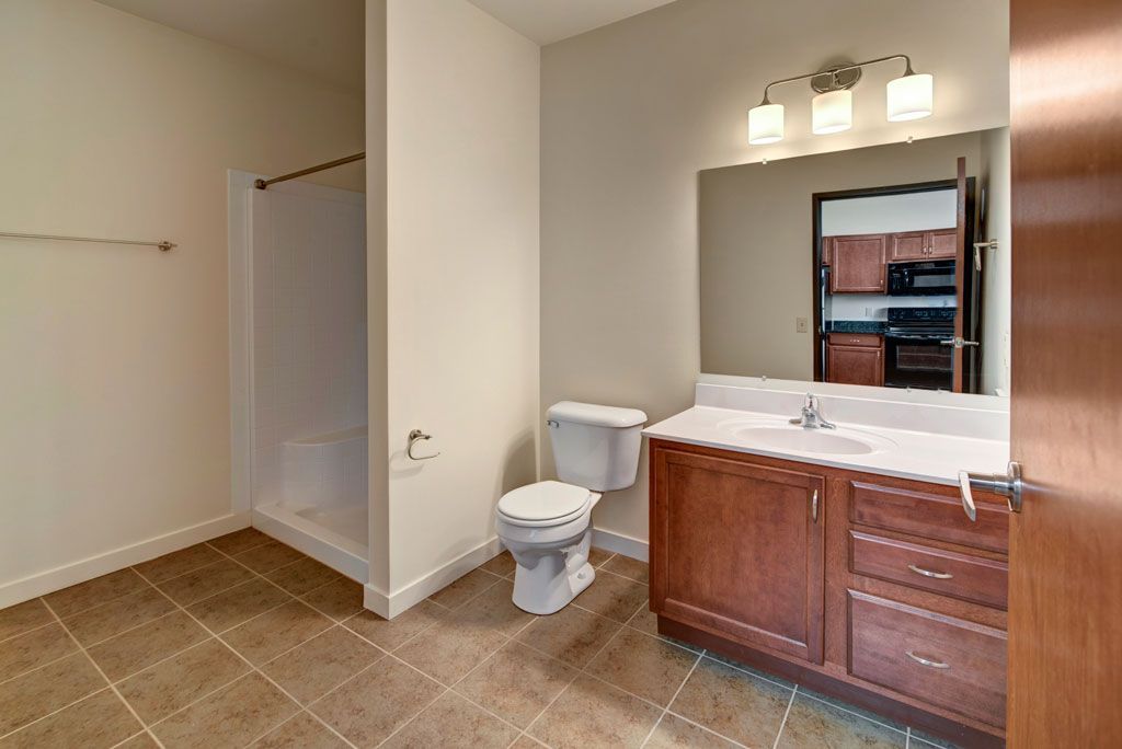 A bathroom with a toilet , sink , and mirror.