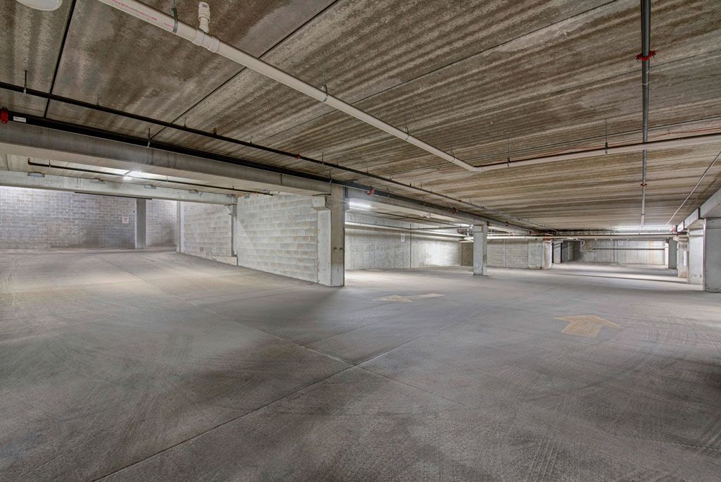 An empty parking garage with a concrete floor and ceiling.