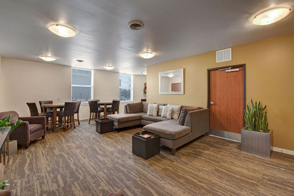A living room with a couch , chairs , tables and a door.