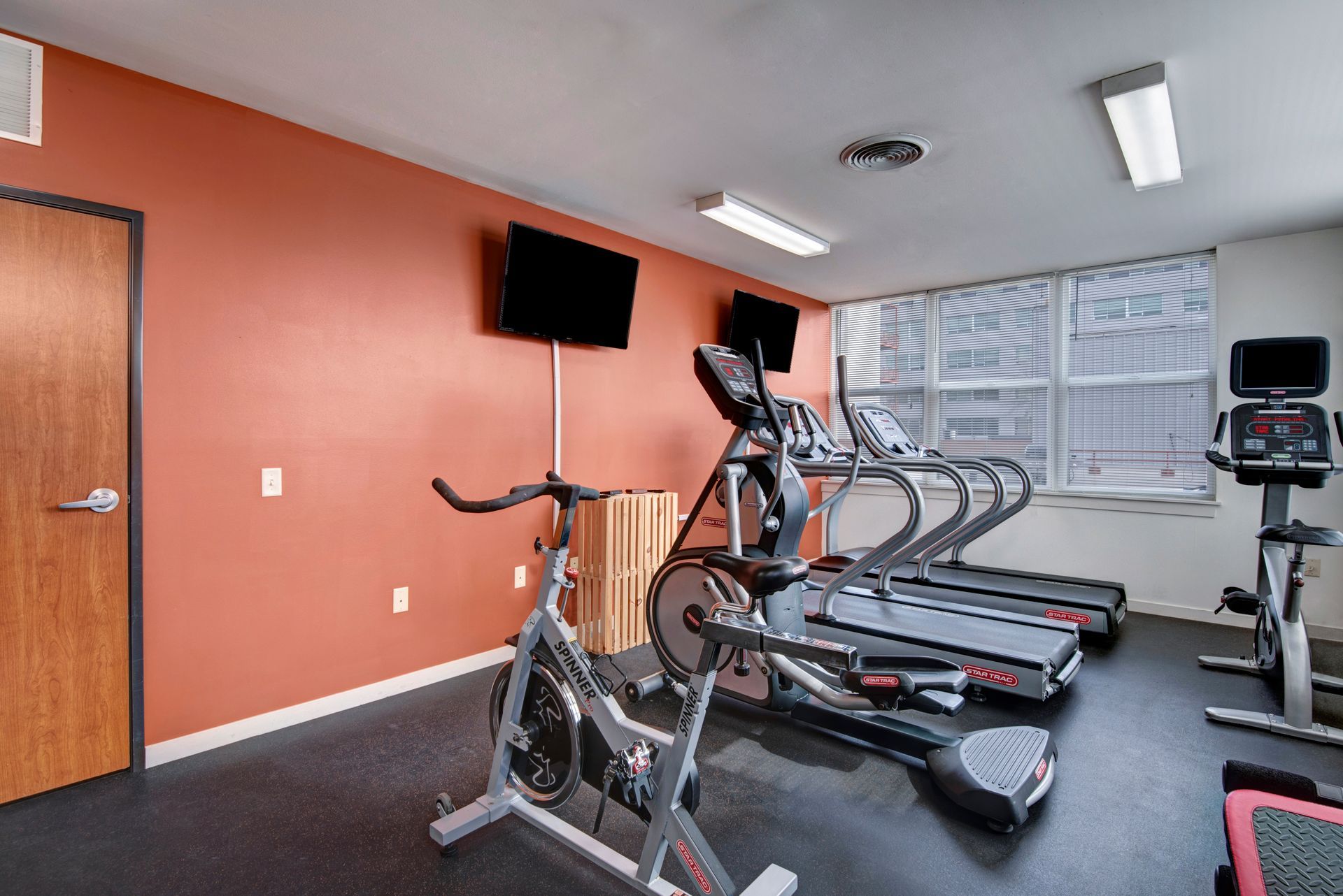 A gym with exercise bikes , treadmills , and a television.