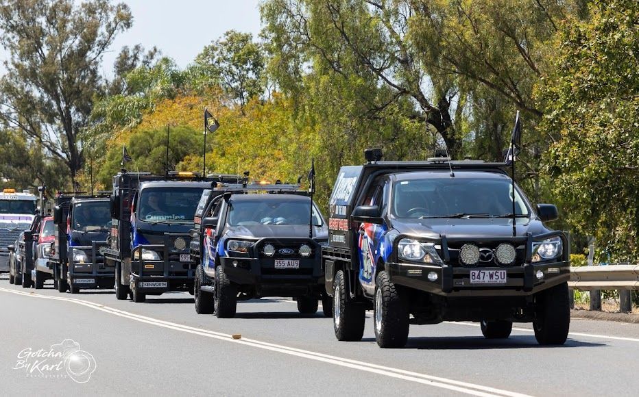 A Row of Trucks Are Driving Down a Highway — Trucks On The Run Pty Ltd in Wilsonton, QLD