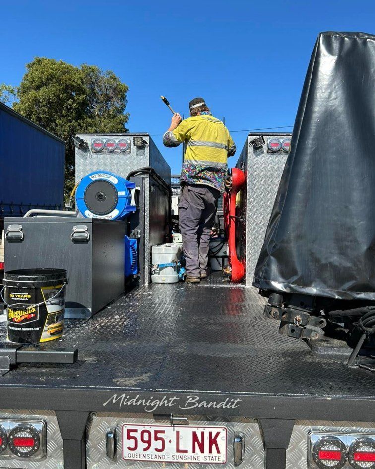 A Man is Standing on the Back of a Truck — Trucks On The Run Pty Ltd in Cecil Plains, QLD