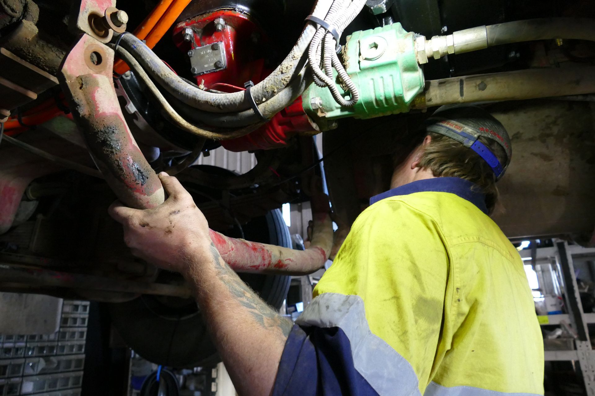 A Man is Working on the Underside of a Vehicle — Trucks On The Run Pty Ltd in Wilsonton, QLD