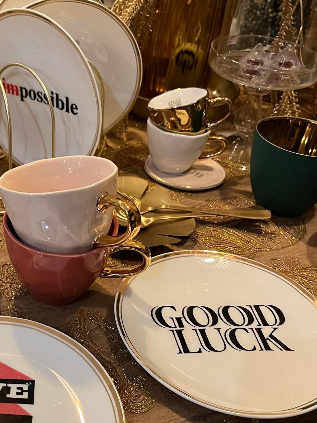 Une table avec des assiettes et des tasses et une assiette qui dit bonne chance