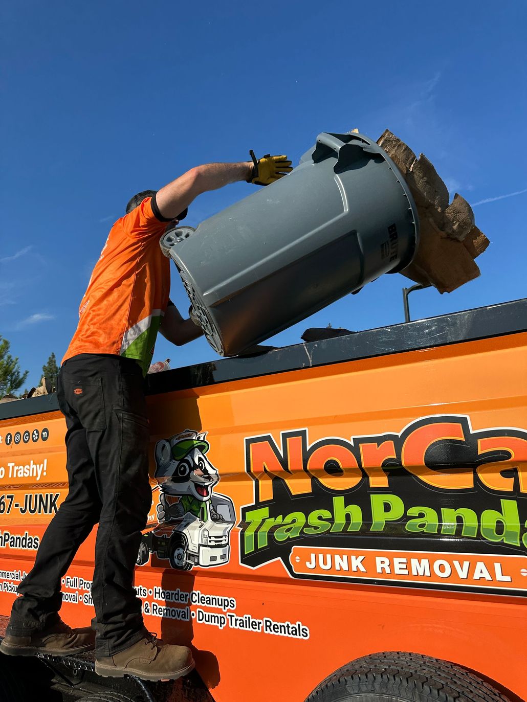 A man is standing in front of a pile of trash.