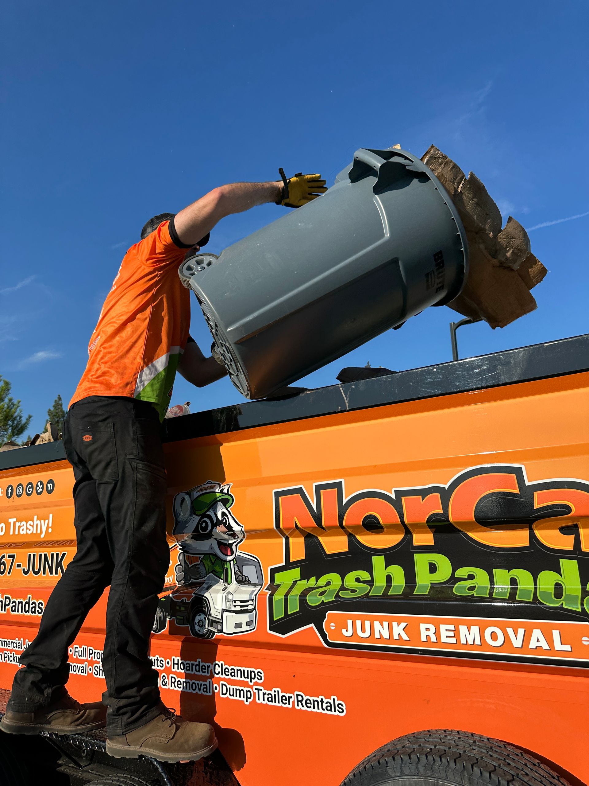 A man is standing in front of a pile of trash.