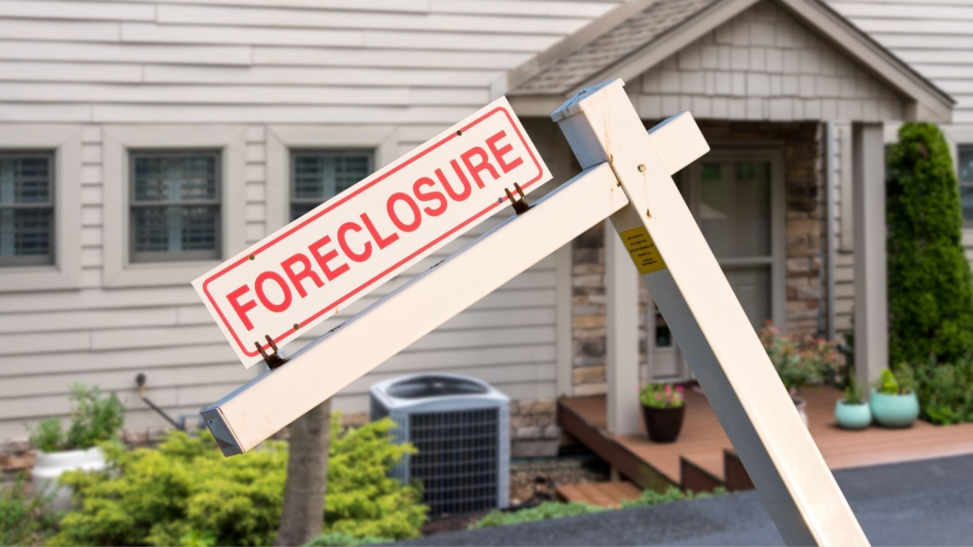 A foreclosure sign is in front of a house.
